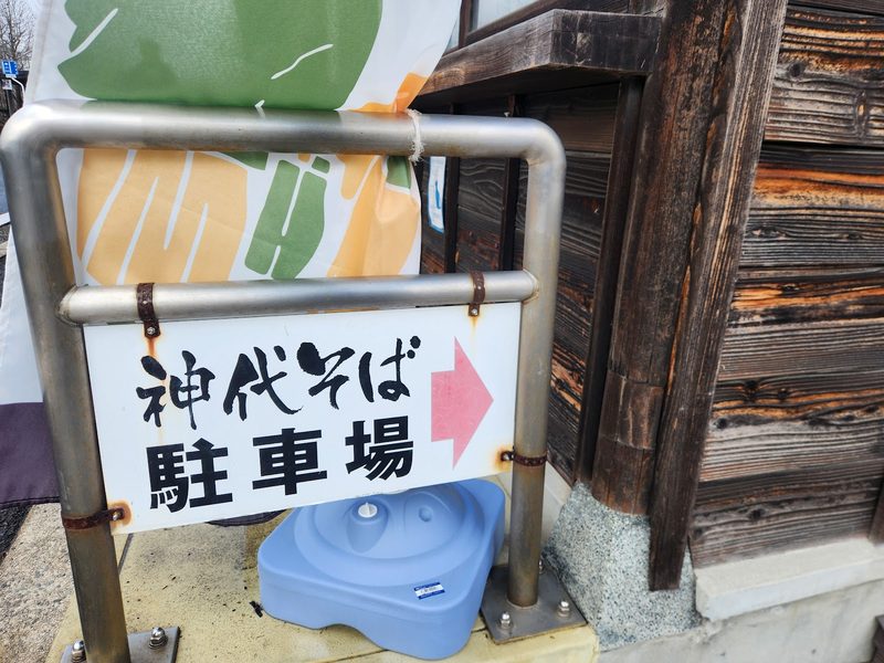 矢印付きの「神代そば 駐車場」の案内看板