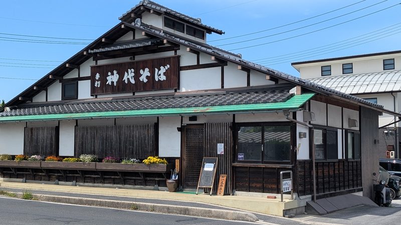 通りに面した店構えと、花の植わったプランター