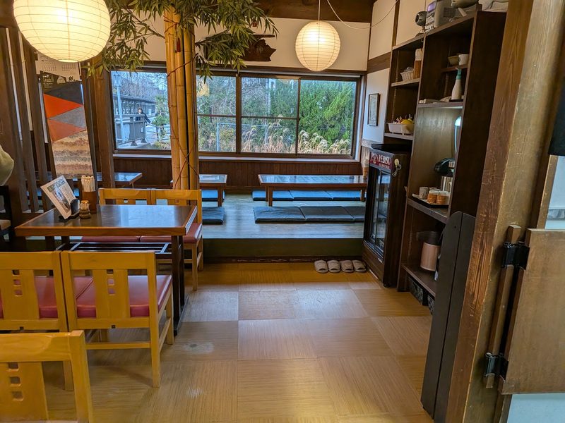 窓から緑が見える、テーブル席と小上がりの店内